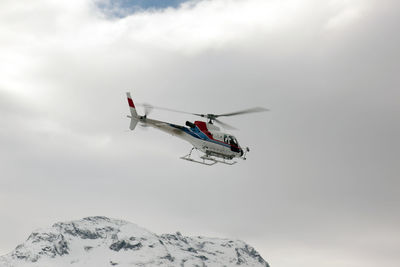 A rescue helicopter flying over the alps mountain