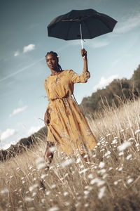 Man standing on wet umbrella against sky