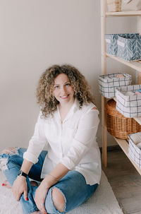 Portrait of smiling young woman sitting at home