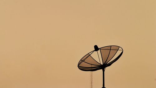 Silhouette satellite dish against clear sky during sunset