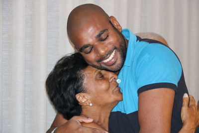 Close-up of mother and son embracing at home