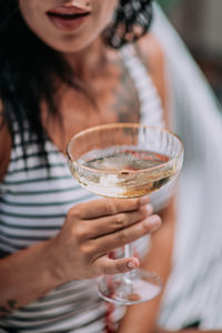 Midsection of woman holding beer glass