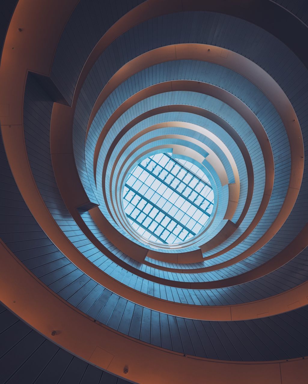 built structure, architecture, pattern, spiral, indoors, steps and staircases, geometric shape, staircase, low angle view, shape, spiral staircase, circle, design, no people, ceiling, directly below, architectural feature, railing, building, modern, skylight, concentric, architecture and art, light at the end of the tunnel