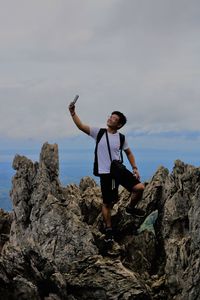 Smiling young man taking selfie on rock formations 