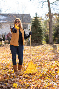 Full length of woman standing by trees during autumn