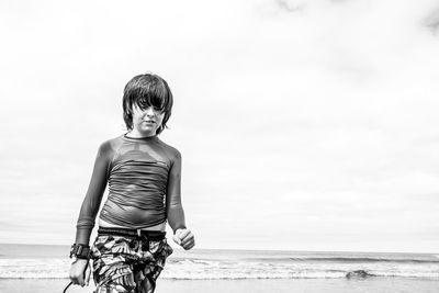 Portrait of boy on beach against sky