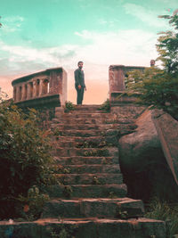 Low angle view of man standing on staircase against sky