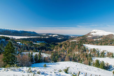 Scenic view of snowcapped mountains against blue sky