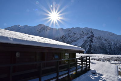 Built structure on snowcapped mountain against sky