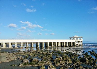 Pier over sea against blue sky