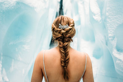 Rear view of woman standing against waterfall