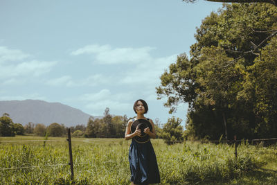 Woman standing on field against sky