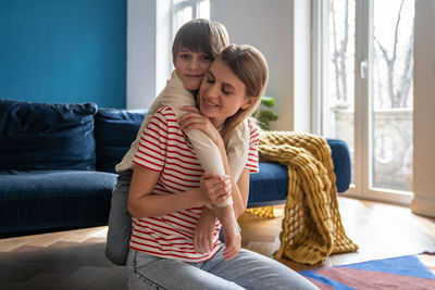 Portrait of young woman sitting on sofa at home