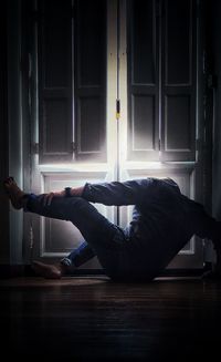 Side view of man relaxing on floor at home