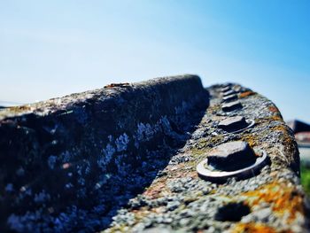 Close-up of rusty metal against blue sky