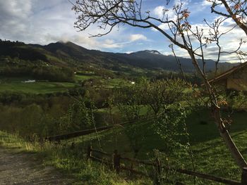 Dirt road by mountains against sky