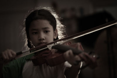 Girl playing violin indoors