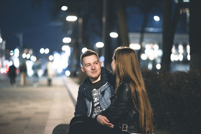 Portrait of young couple sitting outdoors