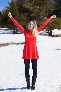 Full length of woman standing with arms raised