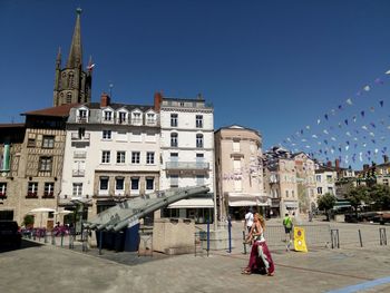 People in front of building against clear sky