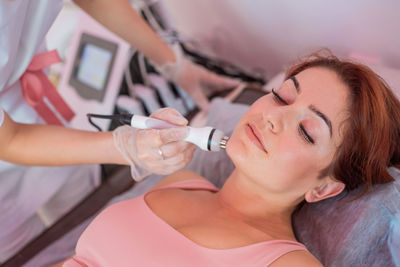 Midsection of woman drinking water at home