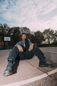 Woman sitting on ground at basketball court