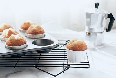 Still life of home made muffins in muffin tray on cooling rack