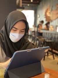 Portrait of young woman using laptop at home