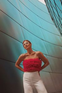 Full length of young woman  stands near a mirrored wall