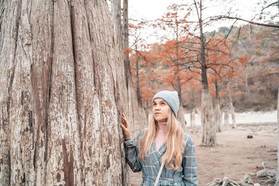 Woman wearing hat against trees
