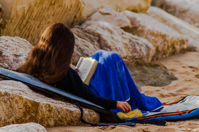 Rear view of woman reading book