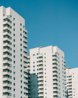 Low angle view of modern buildings against clear blue sky