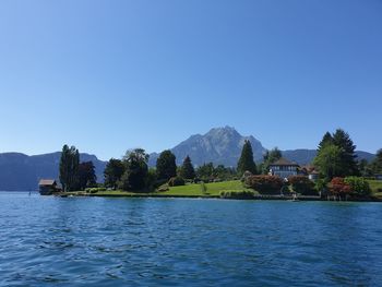 Scenic view of lake against clear blue sky