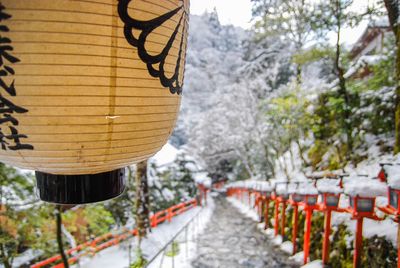 Close-up of lantern against mountains during snowfall