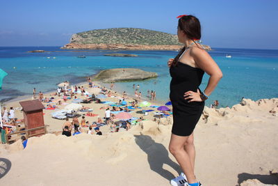 Woman on beach by sea against sky