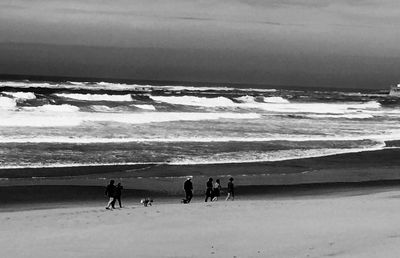 People on beach against sky