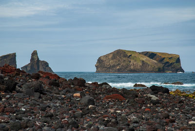 Rocks on beach against sky