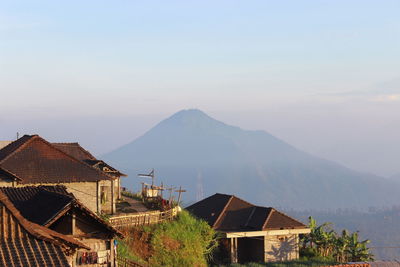 Houses by mountains against sky