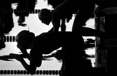 Silhouette men with arms outstretched