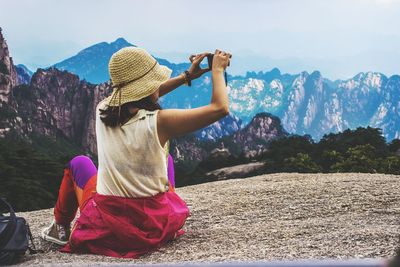 Woman standing on mountain against sky