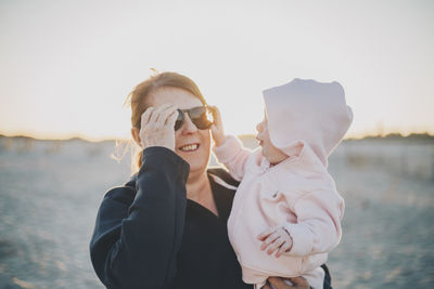 Portrait of grandmother and baby on beach