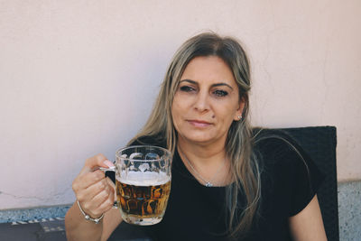 Contemplating mature woman holding beer glass