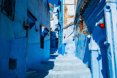 Low angle view of steps amidst houses on sunny day