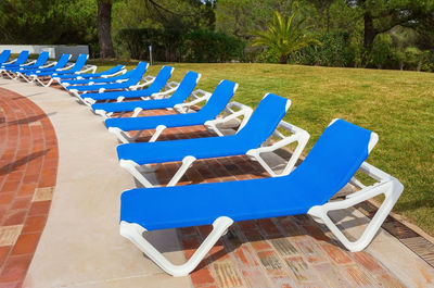Empty chairs by swimming pool