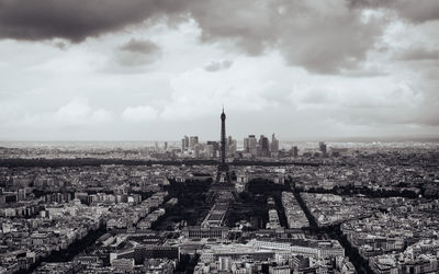 Aerial view of cityscape against cloudy sky