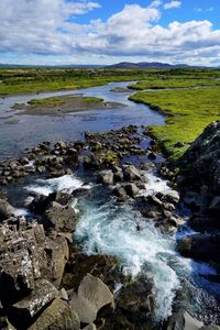 Scenic view of waterfall against sky