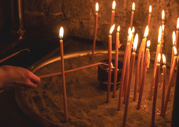 Cropped hand burning candles