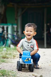 Portrait of cute boy sitting at toy