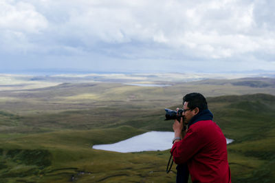 Side view of male photographer photographing at isle of skye