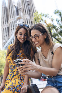 Portrait of smiling young woman using mobile phone